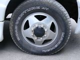 a white truck with a flat tire parked in a parking lot