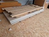 several pieces of plywood sit on the floor of a garage