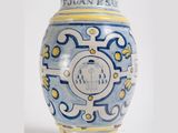 a blue and yellow vase sitting on a white surface