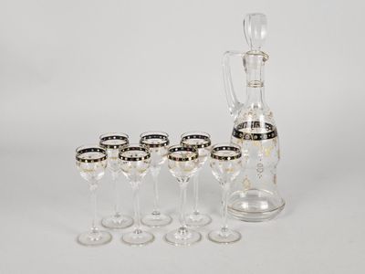 six wine glasses and a decanter on the table