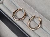 deux paires de boucles d'oreilles créoles en or posées sur un étui noir