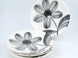 a stack of plates with black and white flowers on them