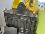 a black stove with a yellow flag on top of it