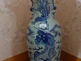 un grand vase bleu et blanc posé sur un parquet