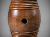 an old wooden vase with a hole in the middle of it