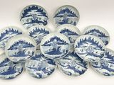 des assiettes bleues et blanches ornées de motifs représentant des montagnes et des arbres