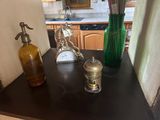 une petite table sur laquelle se trouvent une bouteille et une horloge