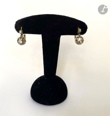 gros plan d'une paire de boucles d'oreilles sur un support noir