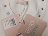 a white shirt with a tag on it and a tag attached to it