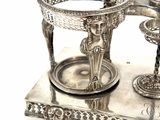 a silver plate with a candle holder on top of it