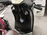 a motor scooter that is parked on the side of the street