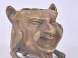 a small statue of a smiling cat on a white surface