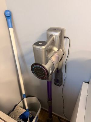 un aspirateur et une serpillière dans un coin de la pièce