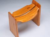 a small wooden bench with a curved seat on it