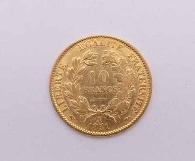 gros plan d'une pièce d'or sur une surface blanche