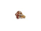 a close up of a diamond and ruby ring on a white background