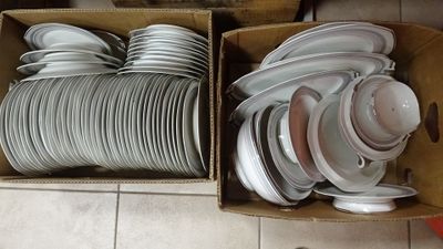 many plates and bowls in a box on the floor