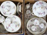 deux cartons contenant des assiettes et des bols en porcelaine