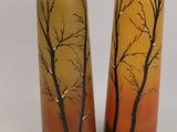 two tall vases with trees painted on them