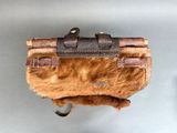 a bag with a fur inside of it hanging on a wall
