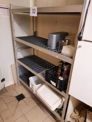une cuisine équipée d'un réfrigérateur et d'étagères sur lesquelles sont rangées des casseroles et des poêles