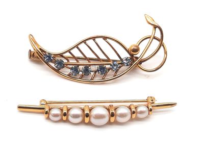 deux broches ornées de perles, posées sur un fond blanc