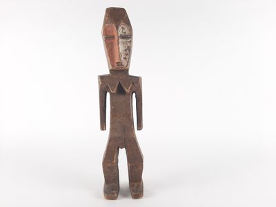 an old wooden statue of a man with a face and legs