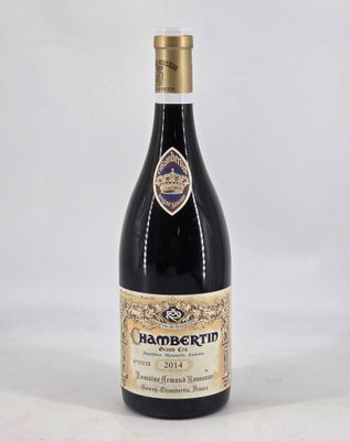 the bottle of wine is sitting on a white surface