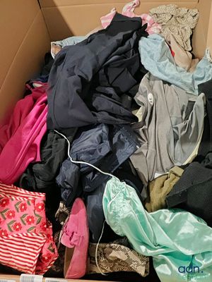 une boîte en carton remplie de vêtements et d'une paire de chaussures