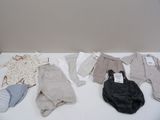 many baby clothes laid out on a white table