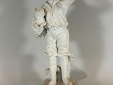 a statue of a boy holding a basket of flowers on a pedestal
