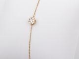 a gold chain bracelet with a flower charm on it