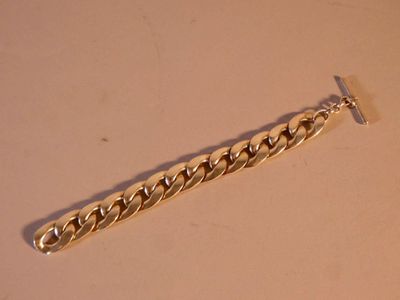 une photo d'un bracelet à chaîne en or posé sur une table