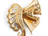 an image of a gold bow brooch on a white background