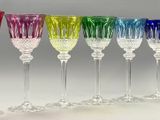 several different colored wine glasses are lined up in a row