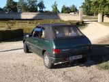 a small green car parked on a gravel road
