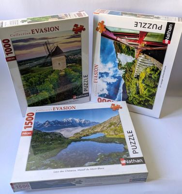 trois puzzles sont posés sur une surface blanche, les uns à côté des autres