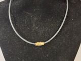 a close up of a necklace on a mannequin with a frisbee in front of it