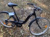 a black bicycle that is parked in the grass
