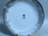 une assiette blanche ornée d'une fleur, posée sur une table