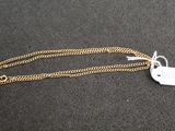 a close up of a gold chain with a tag on it