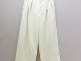 Le pantalon blanc est suspendu à un cintre contre le mur.