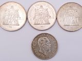 four different types of coins are shown on a white surface