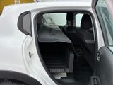 a white car with the door open and the back seat down
