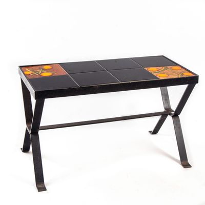 une photo d'une table carrelée de noir et d'orange, avec un piètement en métal