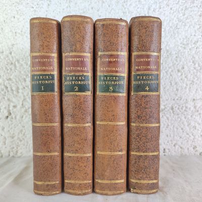 three old books sitting on top of a table next to each other
