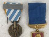 three medals are placed on a white surface with a blue ribbon