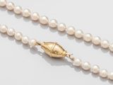gros plan d'un collier de perles sur une surface blanche
