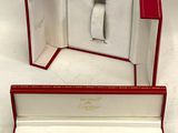 a box with a watch inside of it on a white surface