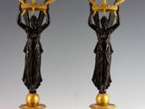 pair of black and gold candlesticks with a lady holding a basket of flowers